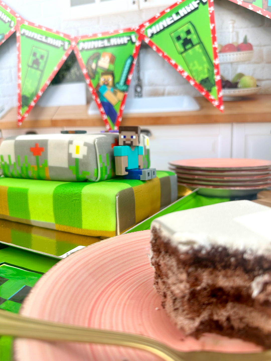 Minecraft®-Figur auf zweistöckiger Spielewelt-Torte