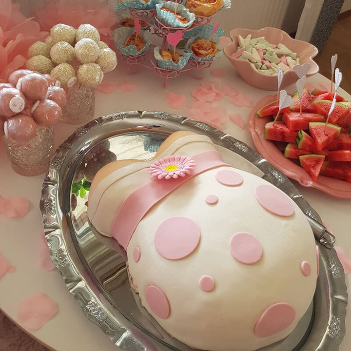 Babybauch-Torte mit rosa Band